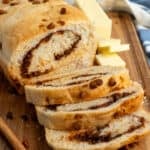 Sliced cinnamon swirl bread on a wood cutting board.