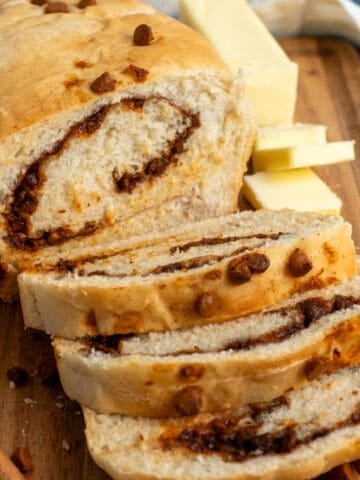 Sliced cinnamon swirl bread on a wood cutting board.