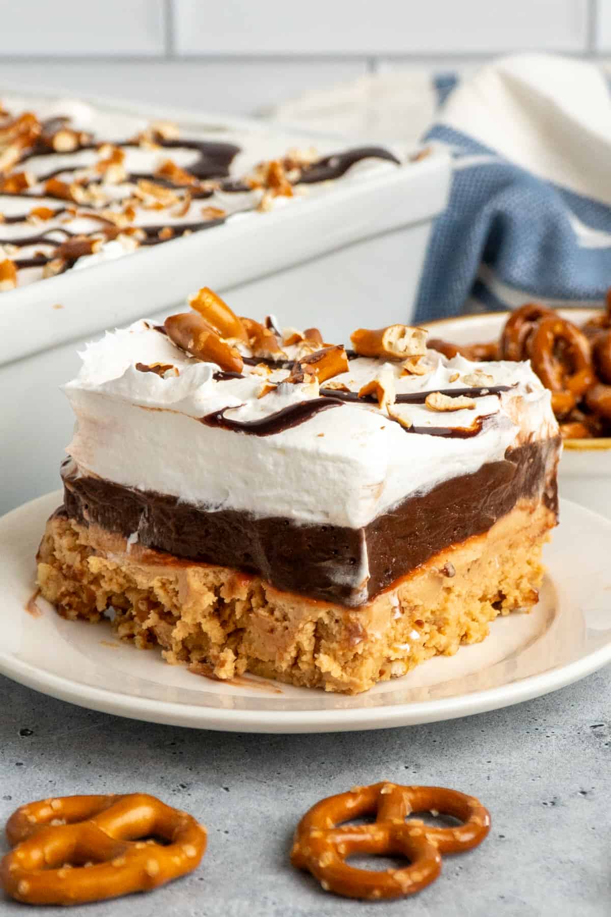 Close up of a slice of peanut butter pretzel pie on a white plate.