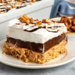 Close up of a slice of peanut butter pretzel pie on a white plate.