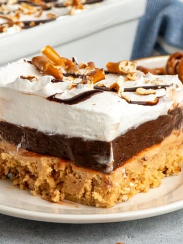Close up of a slice of peanut butter pretzel pie on a white plate.