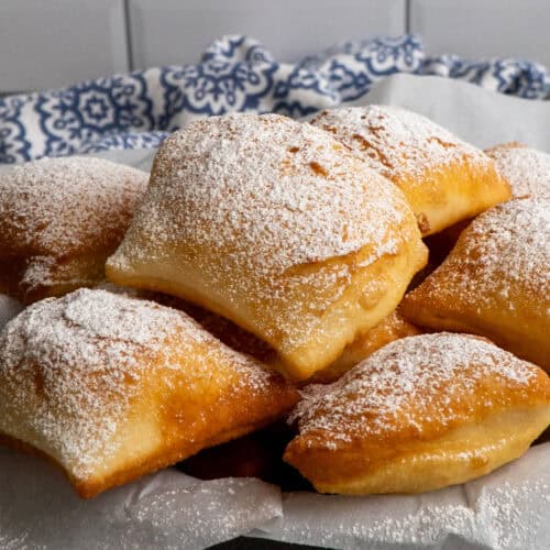 Close up of beignets in a basket.
