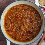 Cowboy beans in a dutch oven on the table.