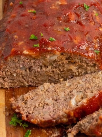 Close up of a smoked meatloaf with two pieces cut off.