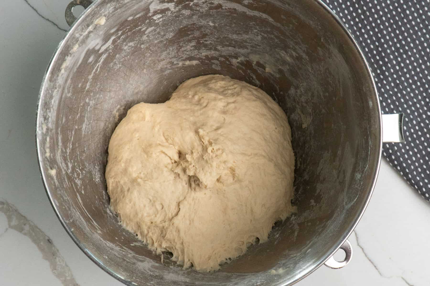Overhead look at dough in a mixing bowl.