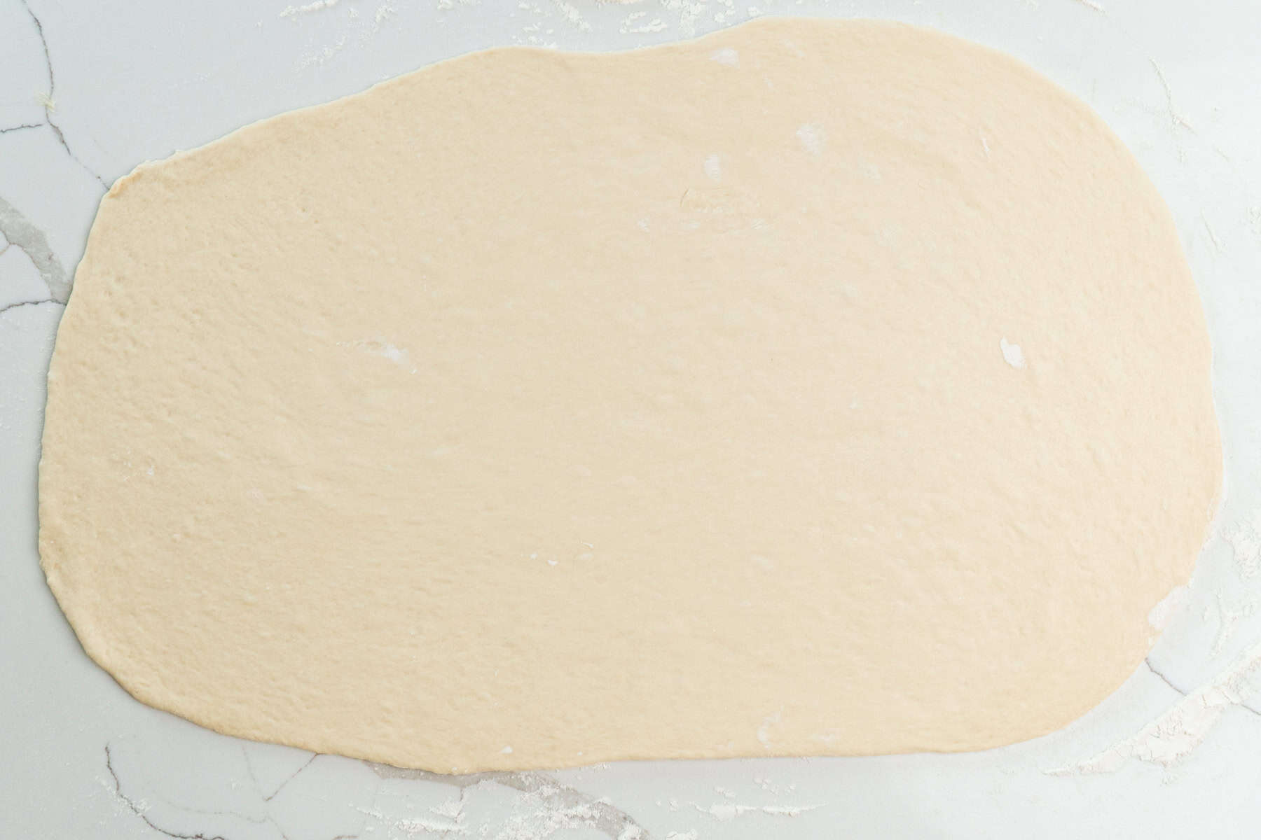 Rolled out dough on a floured surface.