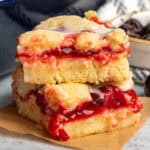 Two cherry bars stacked on top of each on a piece of parchment paper.