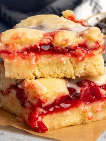 Two cherry bars stacked on top of each on a piece of parchment paper.