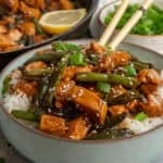 Close up of chicken and green bean stir fry over a bowl of rice.