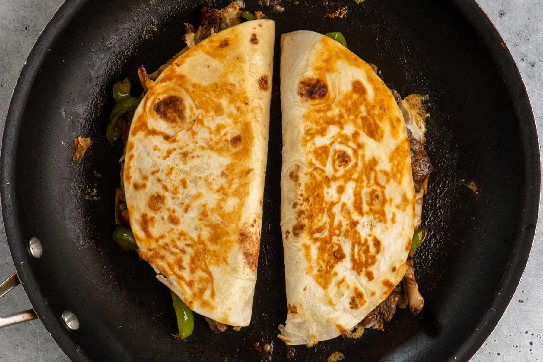 Quesadillas being cooked in a skillet.