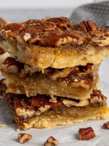 Three pecan pie bars stacked on top of each other.