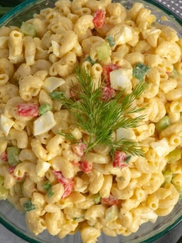 A bowl of devilled egg pasta salad garnished with green onions.