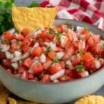 Authentic Pico de Gallo in a bowl with a chip in it ready to be served.