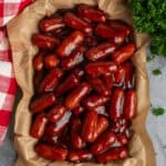Crock pot little smokies on a tray with parchment paper.