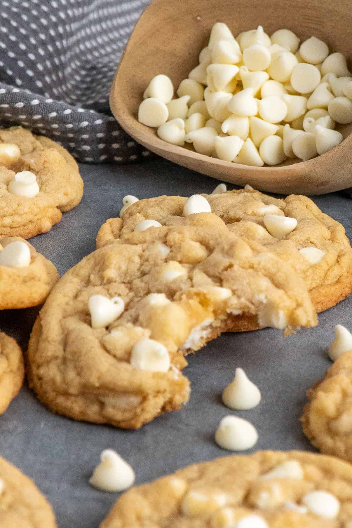 A white chocolate & macadamia nut cookie wit a bite taken out of it.