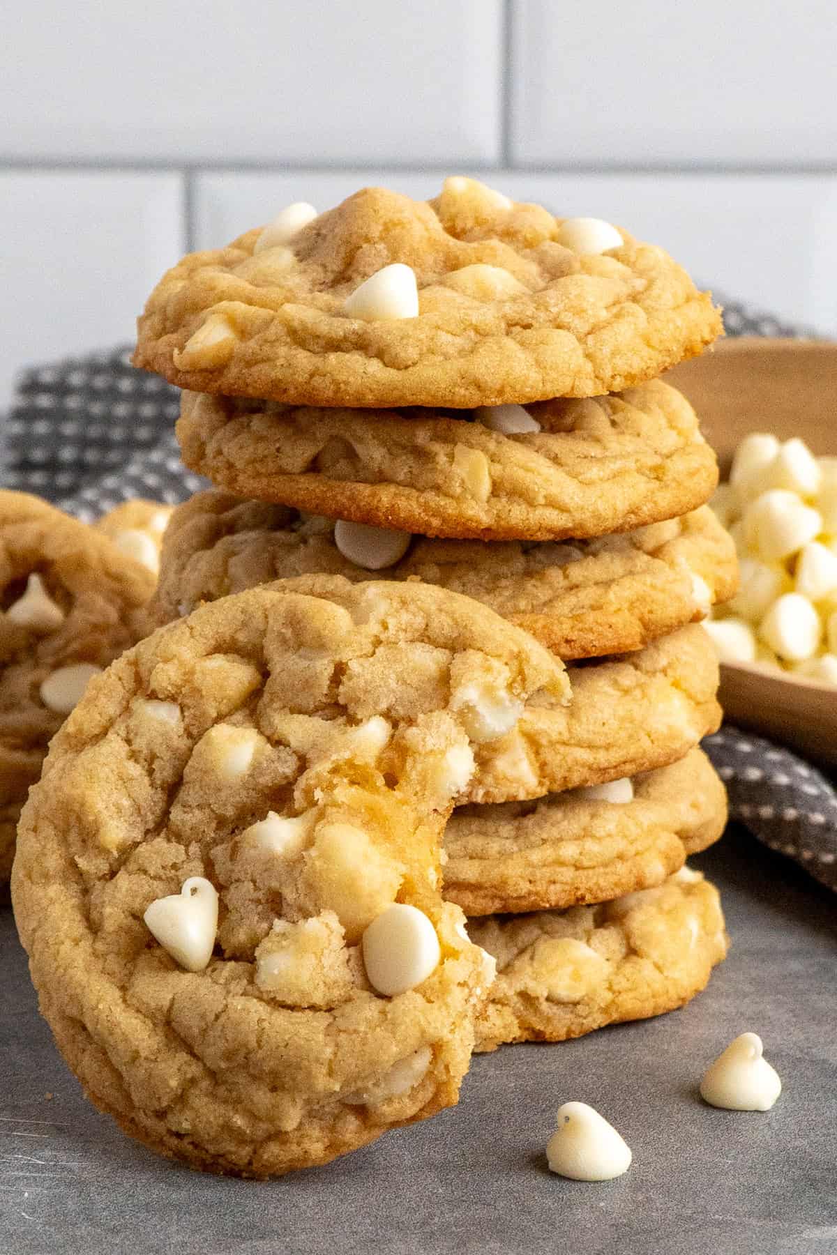 Six white chocolate & macadamia nut cookie stacked up on top of each other.