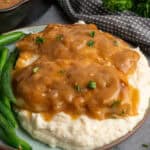 Chicken and gravy over a plate of mashed potatoes.