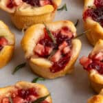 Cranberry brie bites scattered on a piece of parchment.