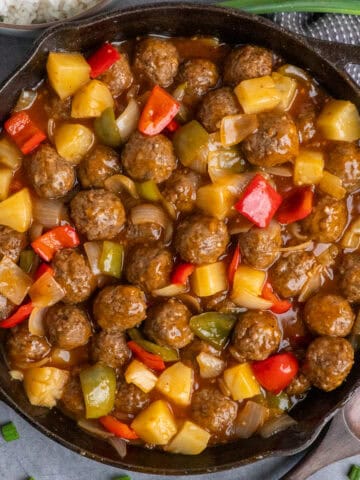 Sweet and sour meatballs in a cast iron skillet.