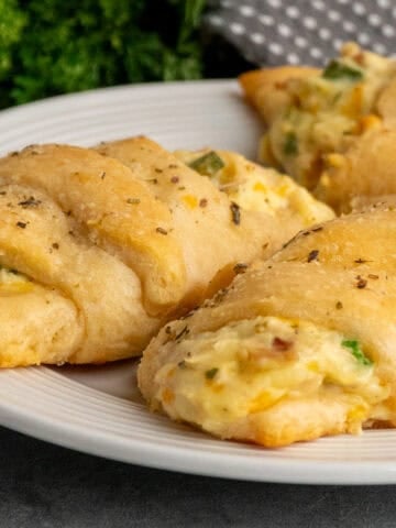 Three chicken crescent rolls on a plate.