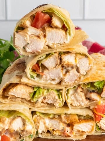 Grilled chicken wraps stacked on top of each other.