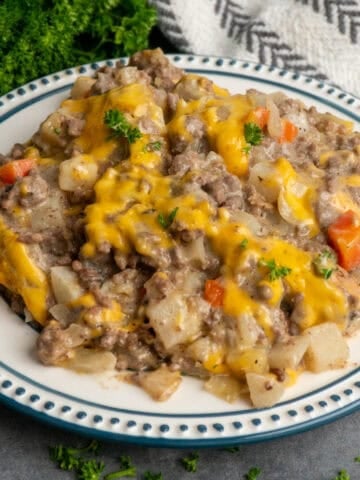 Hobo casserole on a plate with parsley in the background.