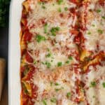 Stuffed manicotti recipe baked in a white casserole dish.