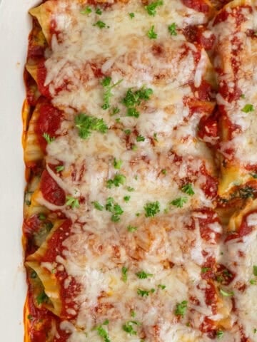Stuffed manicotti recipe baked in a white casserole dish.