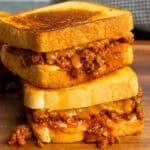 Two sloppy Joe grilled cheese sandwiches stacked on top of each other.