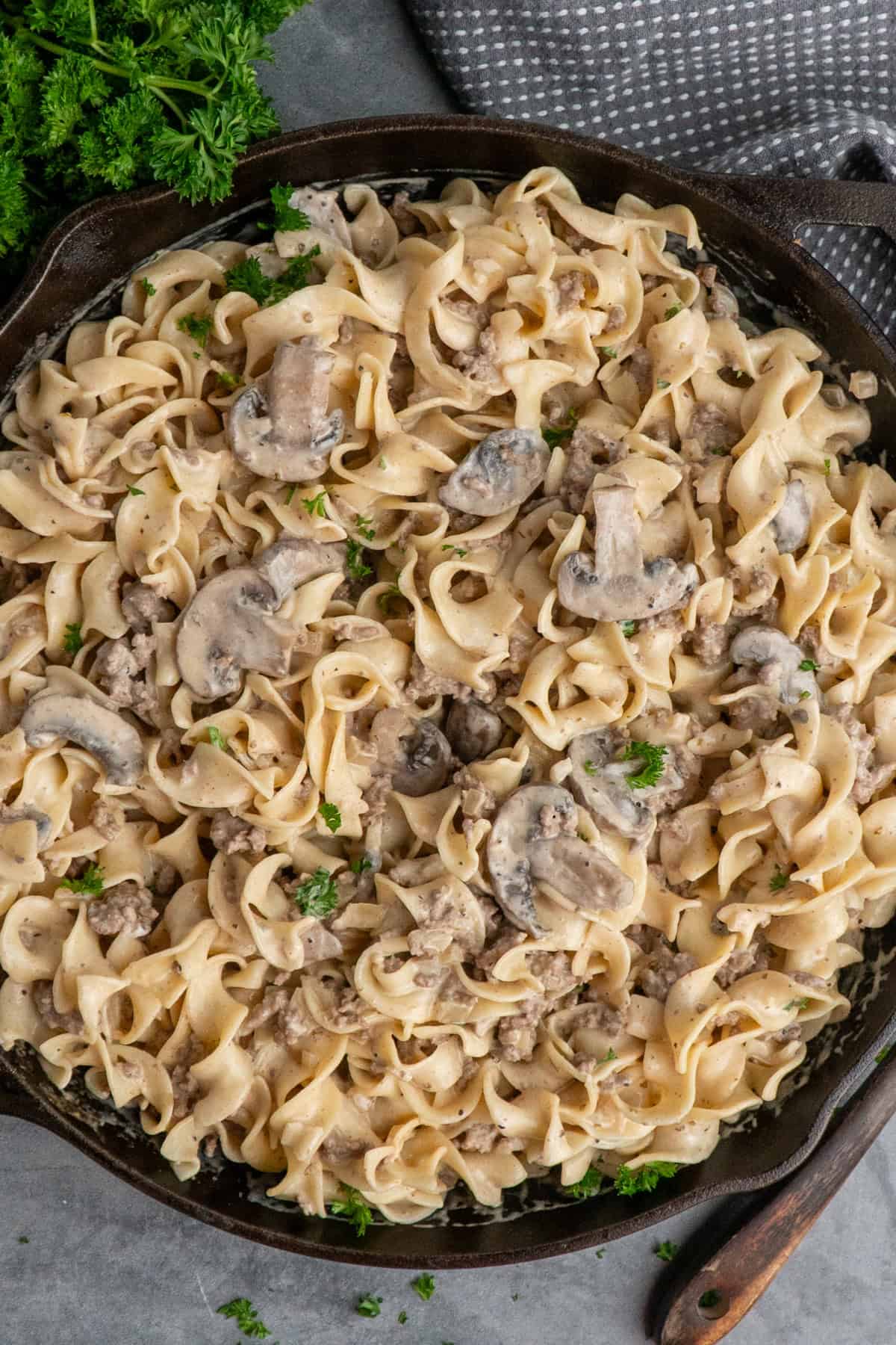 Noodles mixed in with ground beef and stroganoff sauce in a skillet.