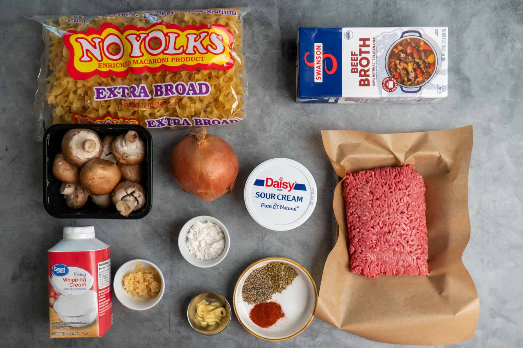 Ingredients to make ground beef stroganoff on a gray countertop.