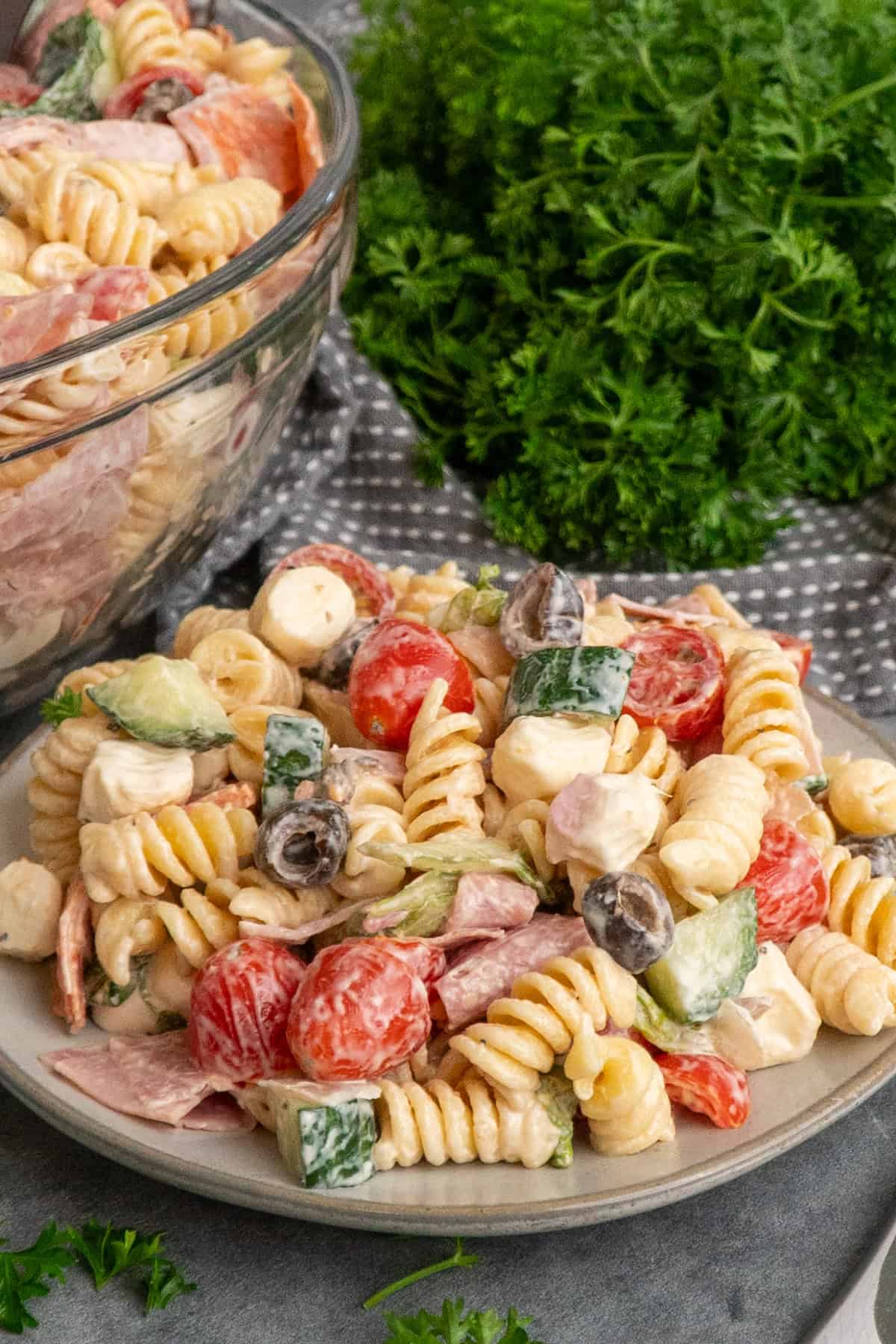 Italian grinder pasta salad on a plate and in a bowl ready to be eaten.