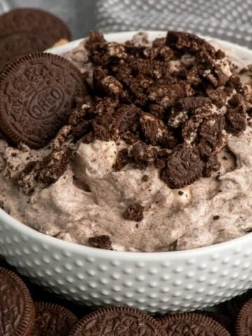 Oreo fluff in a white bowl with Oreo cookies around it.