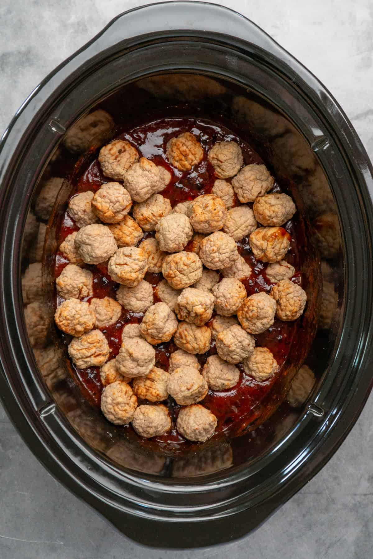 Frozen meatballs added to grape jelly sauce.