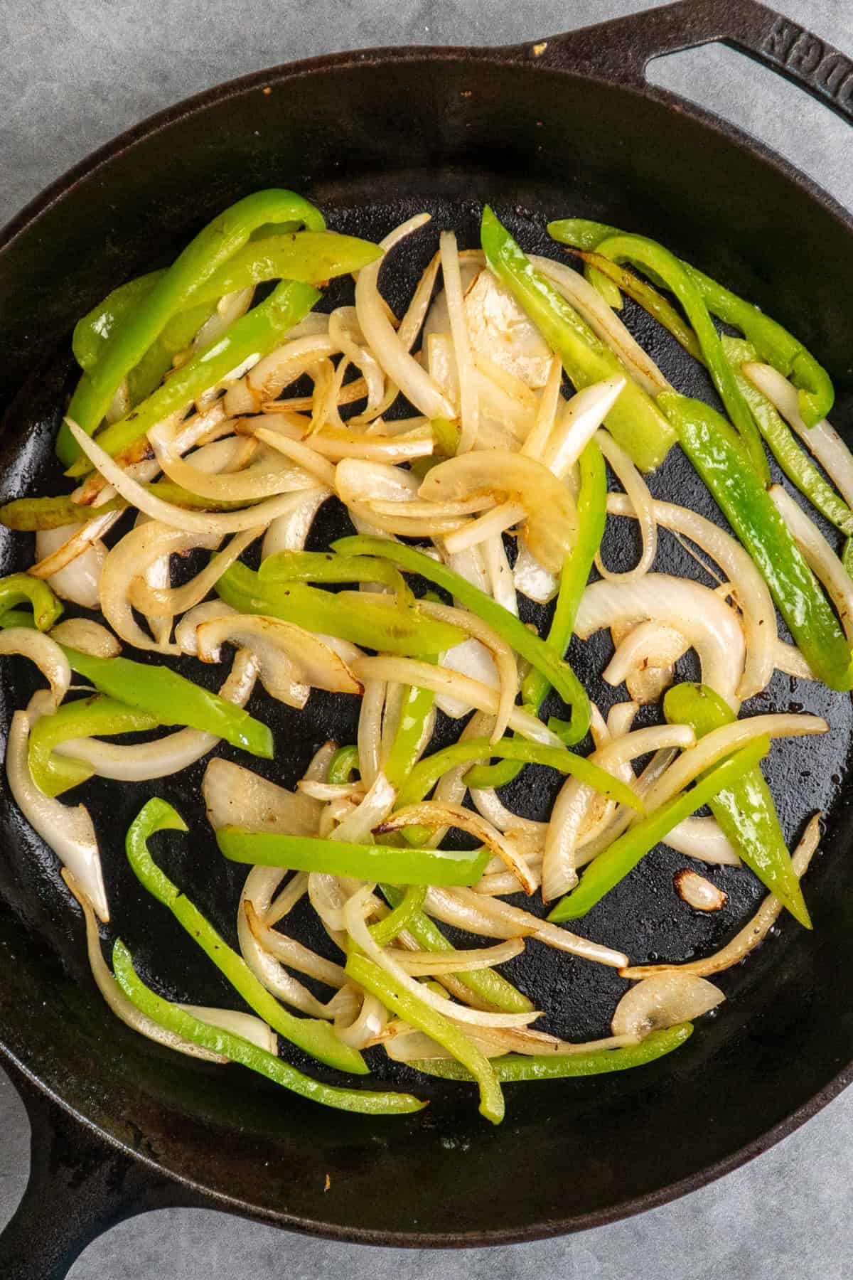 Sauteed onions and peppers in a skillet.