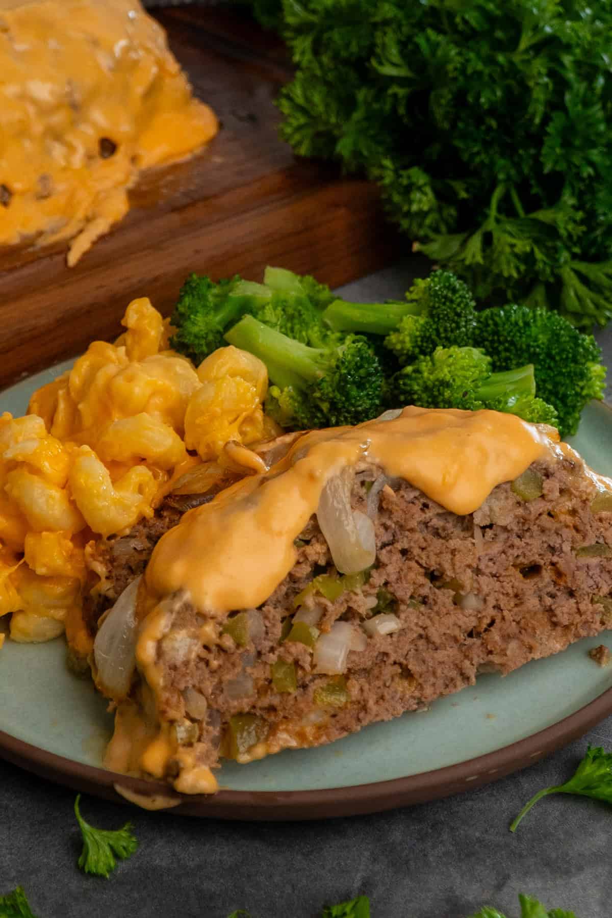 Philly cheesesteak meatloaf on a plate with mac and cheese.