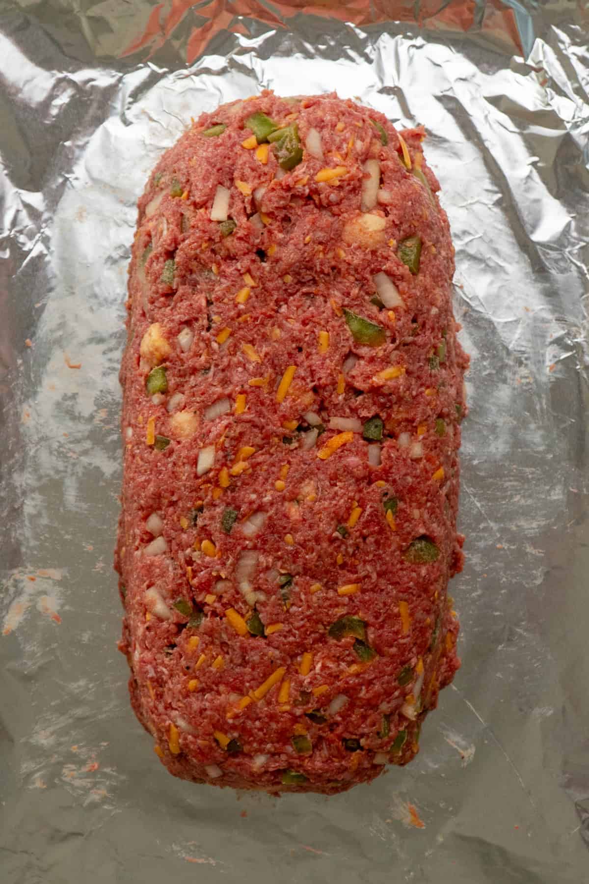 Meatloaf shaped on a foil lined baking sheet.