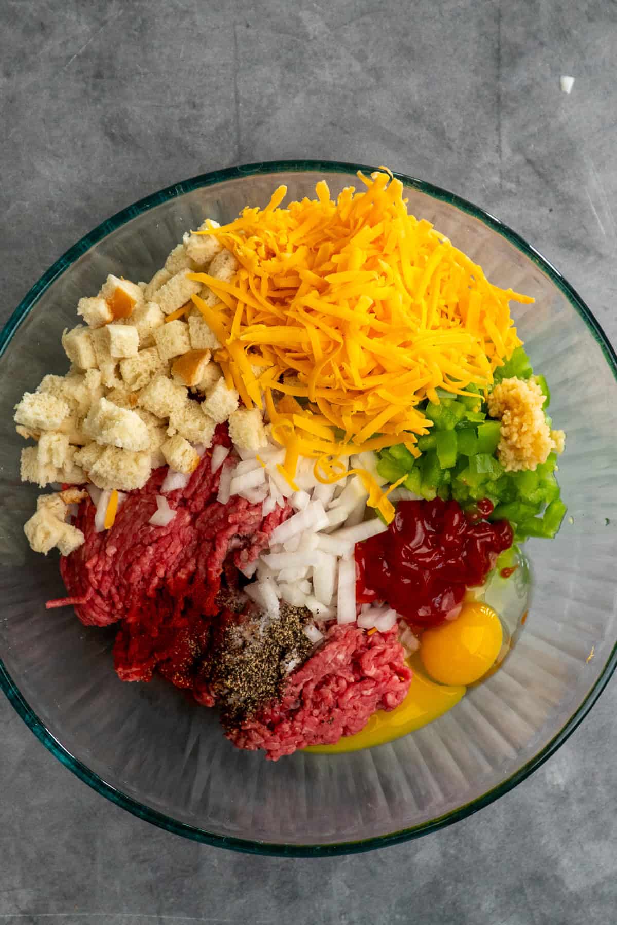 Philly cheesesteak meatloaf ingredients in a bowl ready to be mixed together.