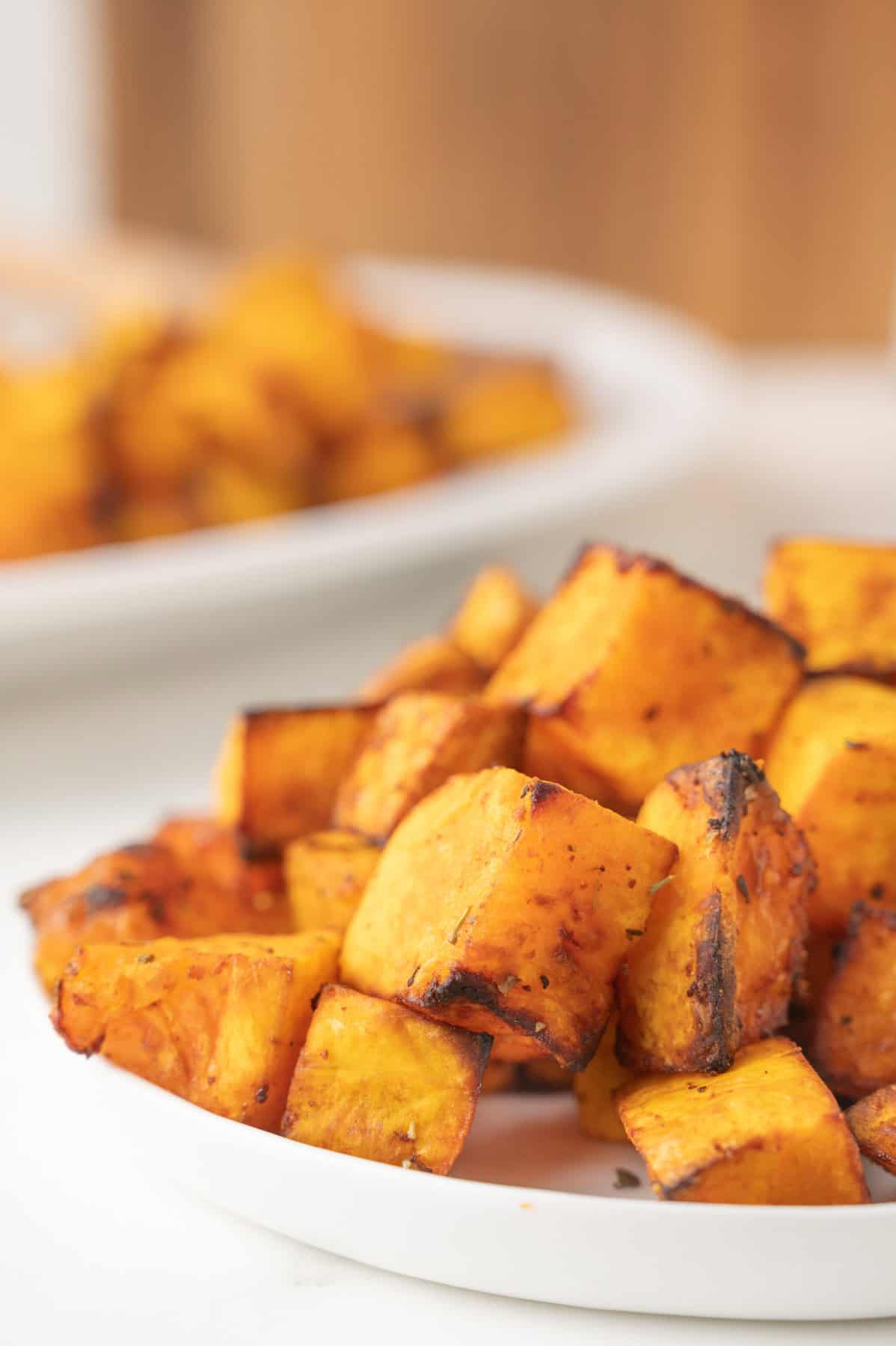 Air fried butternut squash cut into cubes on a plate.