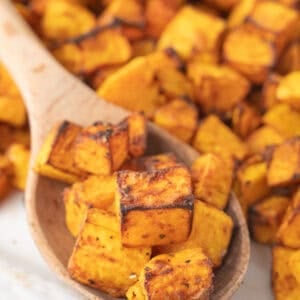 Air fryer butternut squash scooped with a wooden spoon.
