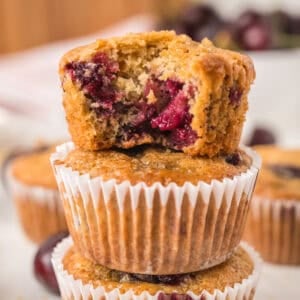 A bite taken out of the top cherry muffin stacked on more.