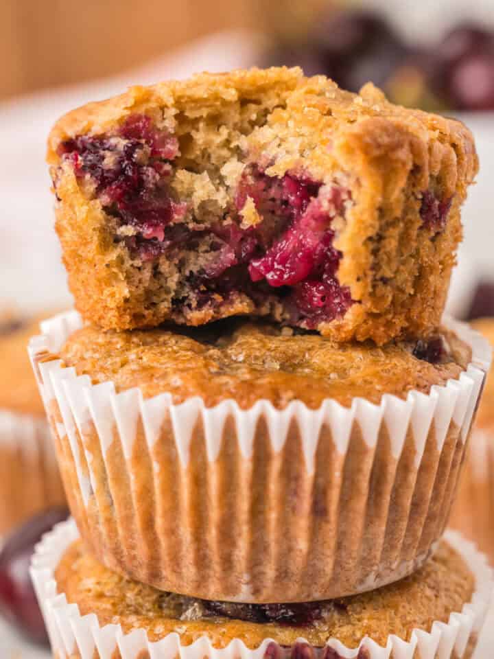A bite taken out of the top cherry muffin stacked on more.