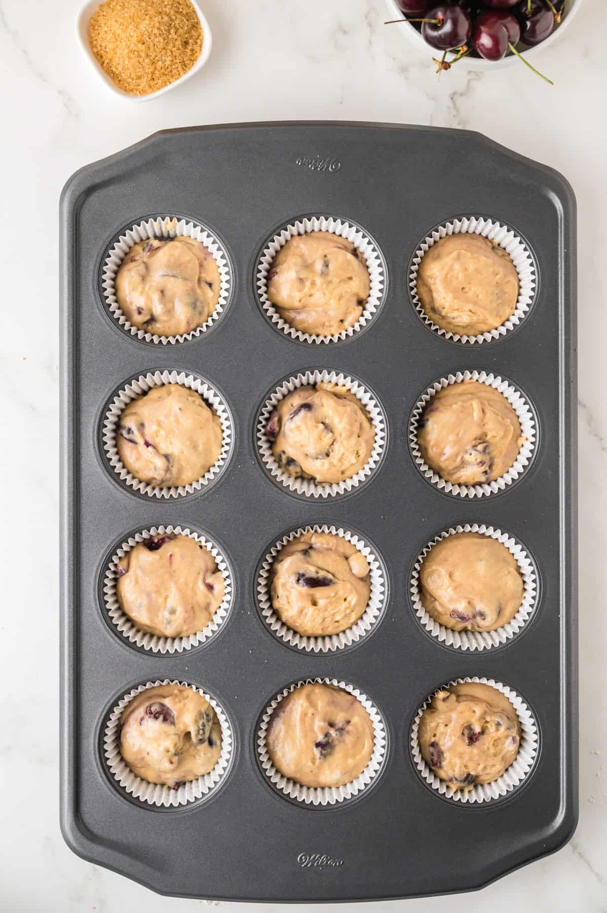Batter mixture added to a muffin tin.