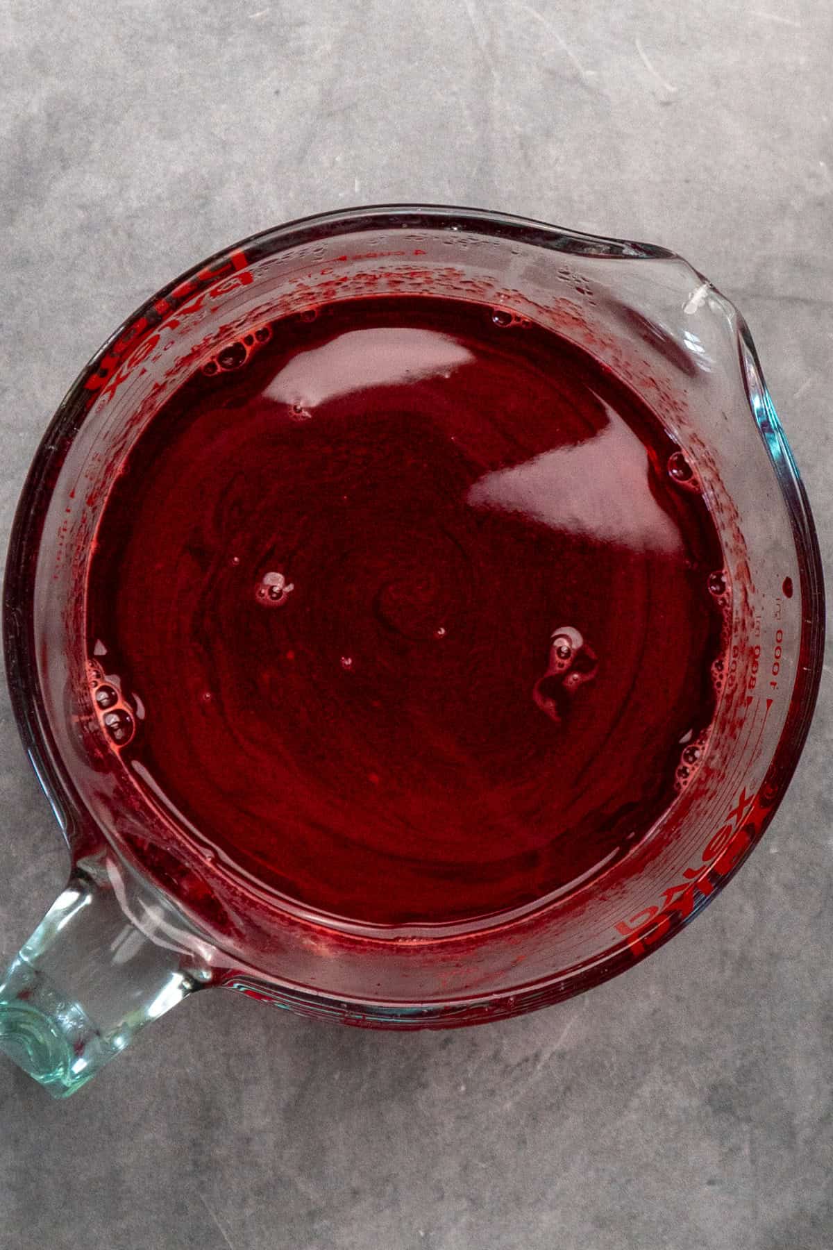 Raspberry jello mixed together with hot water.