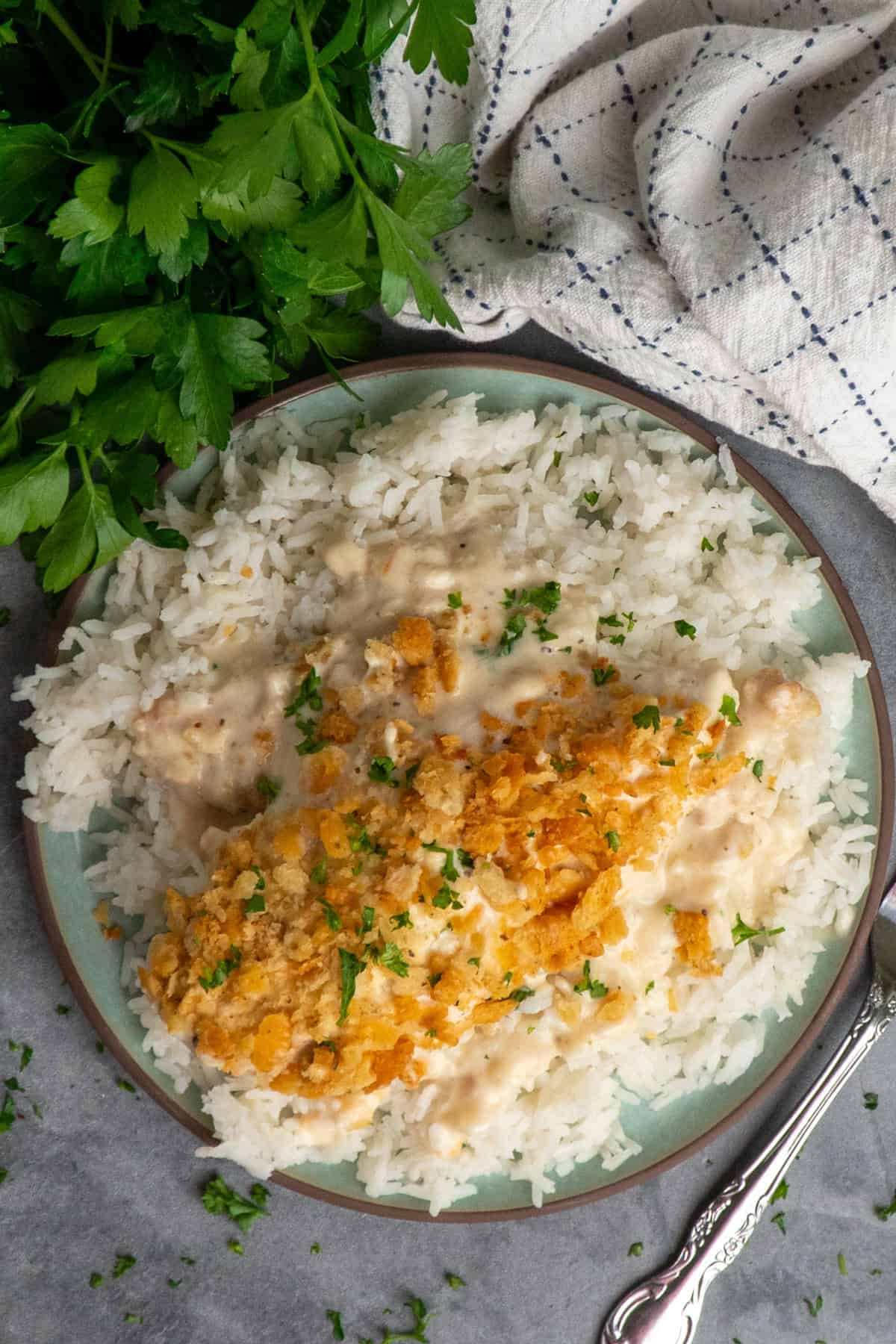 A plate of white rice with chicken and ritz cracker topping.