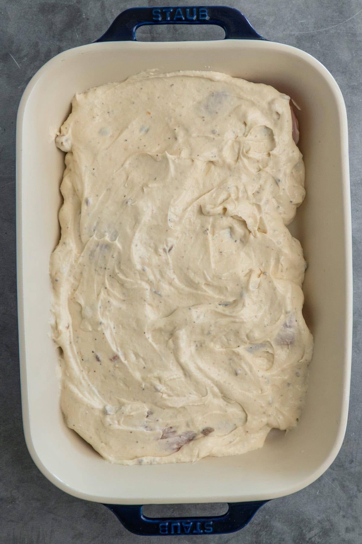 Chicken coated with the sauce in a dish.