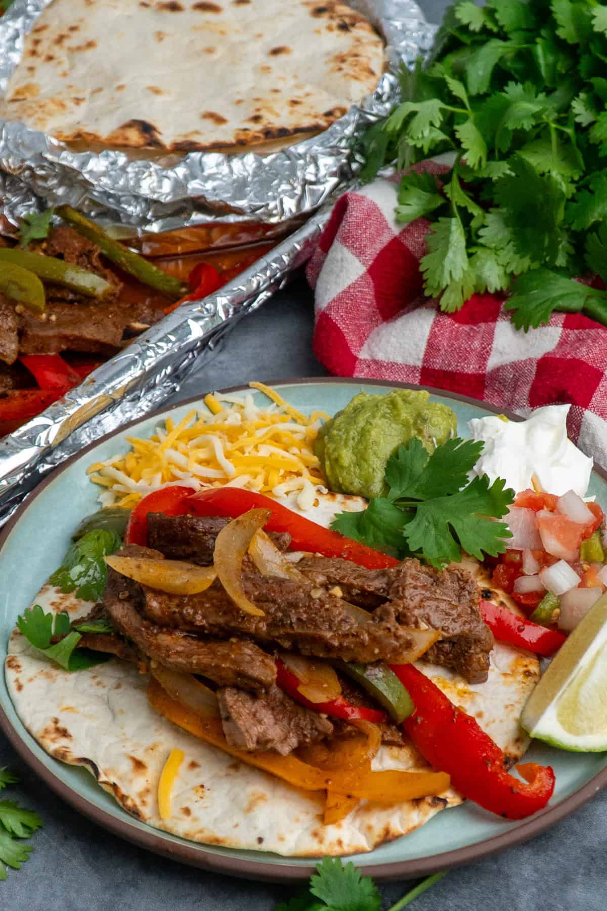 Steak, peppers and onions on a tortilla with cheese, guacamole and sour cream.