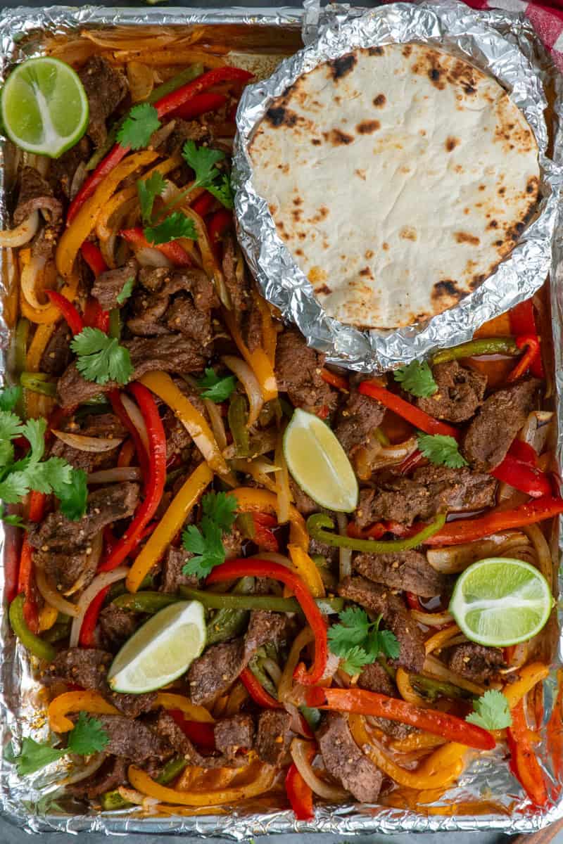 Steak, peppers and onion cooked on a sheet pan.