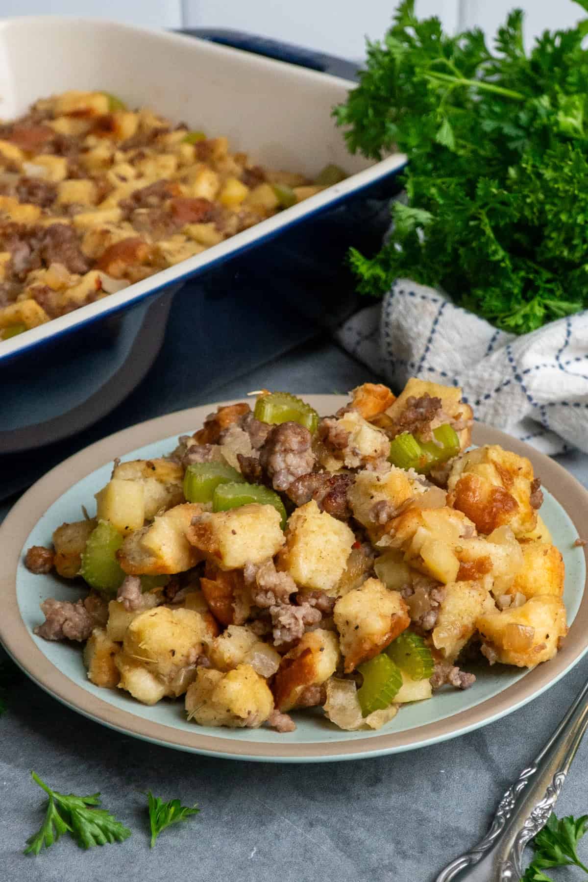 Sausage stuffing on a plate and in a blue baking dish ready to be served.