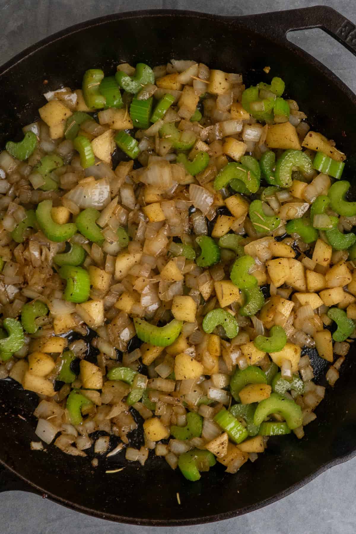 Celery, onion and apple cooking in a cast iron skillet.